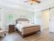 Serene main bedroom with a tray ceiling, wood-look floors, and lots of natural light from large windows at 1271 Thoroughbred Trl, Sanford, FL 32771