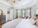 Spacious main bedroom with tray ceiling, wood-look floors, and a sitting area by the windows at 1271 Thoroughbred Trl, Sanford, FL 32771
