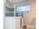 The glass-enclosed shower boasts gray tiling, modern fixtures, a large window, and a unique design at 1271 Thoroughbred Trl, Sanford, FL 32771