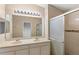 Bathroom featuring double sinks and a shower with glass doors at 12977 Borland St, Windermere, FL 34786