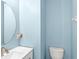 Powder room featuring a round mirror, modern sink and toilet at 12977 Borland St, Windermere, FL 34786
