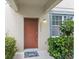 Close up of the home's front door with a modern entry light and tasteful landscaping at 12977 Borland St, Windermere, FL 34786