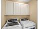 Laundry room with overhead cabinets, washer and dryer at 12977 Borland St, Windermere, FL 34786