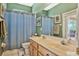 Bathroom with a double sink vanity, a framed mirror and a blue shower curtain at 13111 Meergate Cir, Orlando, FL 32837