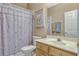 Cozy bathroom features a shower with floral curtain, light wood vanity, and neutral wall color at 13111 Meergate Cir, Orlando, FL 32837