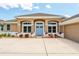 Inviting home featuring a blue front door, arched windows, and a well-maintained front yard with vibrant plants at 13111 Meergate Cir, Orlando, FL 32837