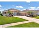 Beautifully landscaped single-story home with a well-manicured lawn, blue front door, and a two-car garage at 13111 Meergate Cir, Orlando, FL 32837