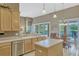 Eat-in kitchen features an island, stainless appliances, and a view of the backyard pool at 13111 Meergate Cir, Orlando, FL 32837