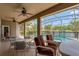 Spacious screened-in patio with comfortable seating, overlooking a pool and beautiful lake view at 13111 Meergate Cir, Orlando, FL 32837