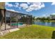 Beautiful view of a screened-in pool and tranquil lake with fountain, creating a serene backyard oasis at 13111 Meergate Cir, Orlando, FL 32837