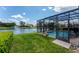 Private pool area with screened enclosure, lush green lawn, and a beautiful view of the serene lake with a fountain at 13111 Meergate Cir, Orlando, FL 32837