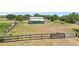 View of a barn with a fenced area, situated on a grassy lot with a black fence at 13124 Filly Ct, Windermere, FL 34786