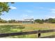 A spacious barn with white accents and a sturdy metal roof sits in an open, grassy field under a clear, blue sky at 13124 Filly Ct, Windermere, FL 34786