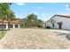 Large brick driveway leading to a three-car garage and a white home with a clay roof at 13124 Filly Ct, Windermere, FL 34786