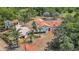 Aerial view of a Spanish-style home with a terracotta roof, lush landscaping, and a circular driveway at 13124 Filly Ct, Windermere, FL 34786