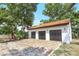 Detached garage with a brick driveway, three bays, clay tile roof, and lush landscaping at 13124 Filly Ct, Windermere, FL 34786