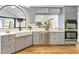 Modern kitchen design showcasing stainless steel appliances, a farmhouse sink, and hardwood floors at 13124 Filly Ct, Windermere, FL 34786