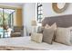 Cozy main bedroom with plush bedding, accent pillows, and a view of the outdoor pool area at 13124 Filly Ct, Windermere, FL 34786