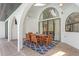 Covered patio area features a wooden table, chairs, decorative rug, and archways that open to the pool area at 13124 Filly Ct, Windermere, FL 34786