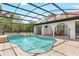 A sparkling screened-in pool with a connected spa, surrounded by tiled decking and lush landscaping at 13124 Filly Ct, Windermere, FL 34786