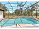 This is a screened-in pool with a spa, tile decking, and a beautiful view of the trees at 13124 Filly Ct, Windermere, FL 34786