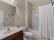 Bathroom features sink vanity, toilet, and shower-tub combo with white shower curtain at 13609 Riggs Way, Windermere, FL 34786