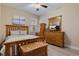 Bedroom with neutral colored walls, ceiling fan, wood-look floors, and wood furnishings at 13609 Riggs Way, Windermere, FL 34786