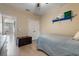 Bedroom with ceiling fan, neutral colored walls, wood-look floors, and large chest at 13609 Riggs Way, Windermere, FL 34786
