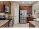 Kitchen featuring stainless steel appliances, granite counters, and dark wood cabinetry at 13609 Riggs Way, Windermere, FL 34786