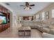 Open-concept living room with wood-look floors, a large sectional sofa, and views into the kitchen at 13609 Riggs Way, Windermere, FL 34786