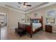 Well-lit main bedroom with a large bed, side tables, bench, and en-suite bathroom access, offering comfort and style at 13609 Riggs Way, Windermere, FL 34786