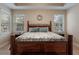 Spacious main bedroom with windows, neutral walls, tray ceiling, and decorative wrought iron bed frame at 13609 Riggs Way, Windermere, FL 34786