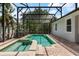 Backyard view of the screened in swimming pool and spa with brick paved patio, and lush landscaping at 13609 Riggs Way, Windermere, FL 34786