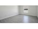 This bedroom includes modern gray floors and a window that let's in plenty of natural light at 1375 Willow Wind Dr, Clermont, FL 34711