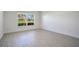 Comfortable bedroom with neutral walls, luxury vinyl flooring, and a large window at 1375 Willow Wind Dr, Clermont, FL 34711