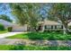 Charming single-story home with lush green lawn and mature trees on a sunny day at 1375 Willow Wind Dr, Clermont, FL 34711