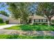 Charming single-story home with lush green lawn and mature trees on a sunny day at 1375 Willow Wind Dr, Clermont, FL 34711