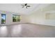 Bright, airy living room with sleek flooring, ceiling fan, and natural light from the large window at 1375 Willow Wind Dr, Clermont, FL 34711
