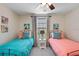 Bright bedroom featuring two twin beds with decorative pillows and matching animal artwork at 1425 Thunderbird Rd, Davenport, FL 33896