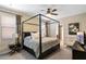 Spacious bedroom with a four-poster bed, ceiling fan, and a cozy ambiance for relaxation at 1425 Thunderbird Rd, Davenport, FL 33896