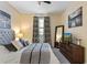Cozy bedroom with gray headboard, dresser, and patterned curtains for a relaxing space at 1425 Thunderbird Rd, Davenport, FL 33896