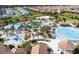 Aerial view of a large community pool area with splashpad, surrounded by palm trees and lounge chairs at 1425 Thunderbird Rd, Davenport, FL 33896