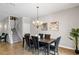 Bright dining room features a modern chandelier, staircase, and seating for six at 1425 Thunderbird Rd, Davenport, FL 33896