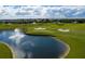 Scenic aerial view of a golf course with a tranquil lake and a picturesque water fountain feature at 1425 Thunderbird Rd, Davenport, FL 33896