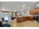 Open-concept kitchen with granite countertops and stainless-steel appliances, leading to a sunny living area and pool view at 1425 Thunderbird Rd, Davenport, FL 33896