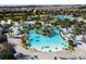 Aerial view of the lazy river and pool area with lounge chairs and palm trees in the community at 1425 Thunderbird Rd, Davenport, FL 33896