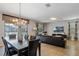 Open-concept living and dining area featuring a chandelier, table for six, and a sofa at 1425 Thunderbird Rd, Davenport, FL 33896