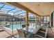 Screened patio with dining table set, offering a view of the inviting private pool area at 1425 Thunderbird Rd, Davenport, FL 33896