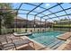 Inviting screened-in pool and spa with lounge chairs on a brick paver deck for relaxation at 1425 Thunderbird Rd, Davenport, FL 33896
