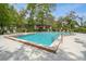 Enjoy the community pool with lounge chairs and a bright red umbrella for shade on a sunny day at 150 Waterfall Way # 102, Altamonte Springs, FL 32714